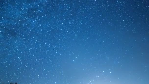 Yıldızlı gökyüzü kutup yıldızının etrafında döner. Karla kaplı tarlalar ve ağaçlar. Kış, Rusya. 4K - Video, Çekim