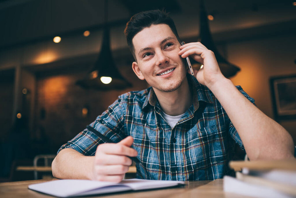 Happy male student in smart casual wear enjoying consultancy conversation during education learning for preparing to university exams, successful man connecting to 4g for making phone communication - Photo, image