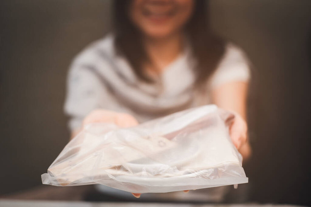 Žena držící talíř a lžíci v restauraci je zabalena v plastu, aby se zabránilo infekci z COVID-19 s úsměvem - Fotografie, Obrázek