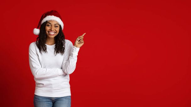 Cheerful african american young woman pointing at copy space - Photo, Image