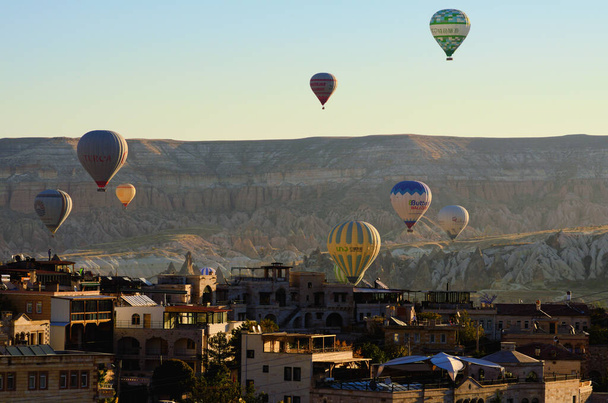Goreme, Turquía-10 de octubre de 2021: Festival de globos aéreos en Capadocia. Globos de aire caliente volando sobre la ciudad de Goreme. Destino popular en Turquía. Patrimonio de la Humanidad UNESCO. - Foto, imagen