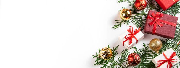 Caixas de presente com fita vermelha e bolas de Natal douradas no fundo branco. - Foto, Imagem