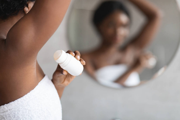 Junge schwarze Frau benutzt Antitranspirant-Stock für Unterarme - Foto, Bild