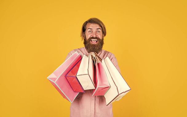 In shopping store. best sale offer. happy bearded man with present pack. cheerful brutal hipster hold gift. paper shopping bag. birthday surprise at party. man with package. prepare for holidays - Φωτογραφία, εικόνα
