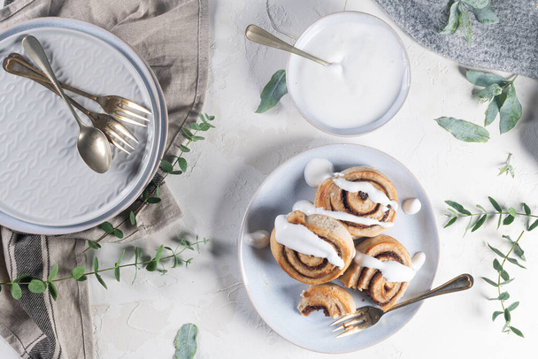 Cinnamon rolls or cinnabon  with icing for Christmas. Homemade traditional winter festive dessert buns. Pastry food for breakfast on white background - Photo, Image