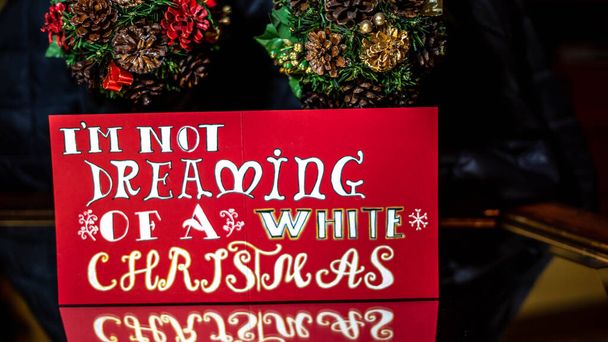 sign that is reflected in a mirror in which you can read I do not dream of a white Christmas - Photo, Image
