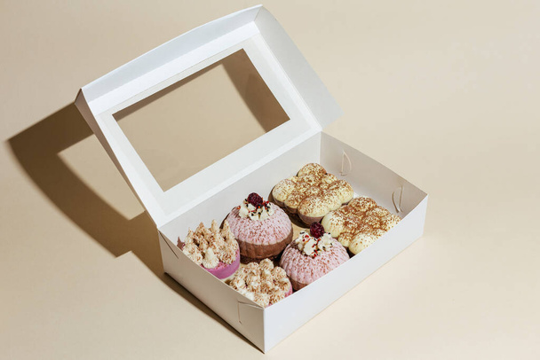 primer plano varios pasteles de chocolate vegano hechos a mano en la caja de regalo en tocino amarillo - Foto, imagen