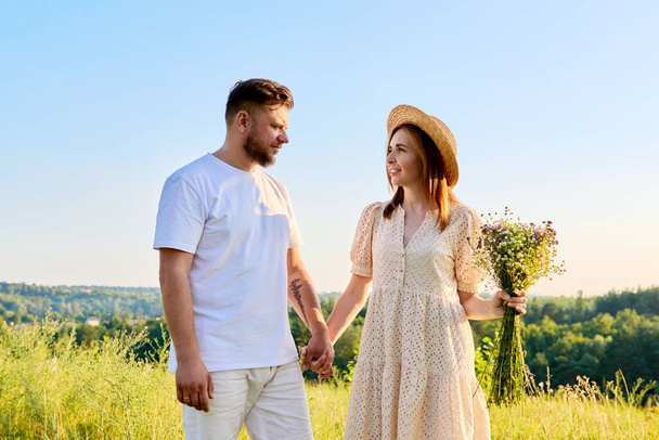 Couple holding hands smiling talking, summer nature blue sky background - Foto, imagen