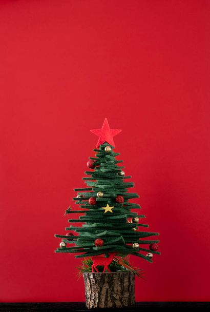 New year, Christmas greeting background with pine tree shaped ornaments over red surface with copy space. new year card, Christmas or noel ornaments.  - 写真・画像