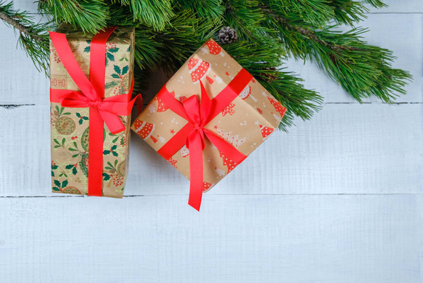 Cajas de regalo de Navidad sobre fondo de madera blanca con rama de árbol de Navidad. Tema Navidad y Feliz Año Nuevo. Asiento plano, vista superior. Copiar espacio - Foto, Imagen