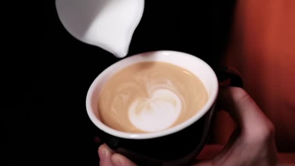 Бариста наливає латте на каву, еспресо. створення ідеального латте мистецтва. темні кольори, кав'ярня. повільний рух
 - Кадри, відео