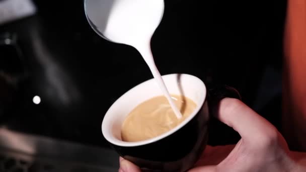 Barista ρίχνει αφρό latte στον καφέ, espresso. δημιουργώντας έναν τέλειο latte art. σκούρα χρώματα, καφενείο. αργή κίνηση - Πλάνα, βίντεο
