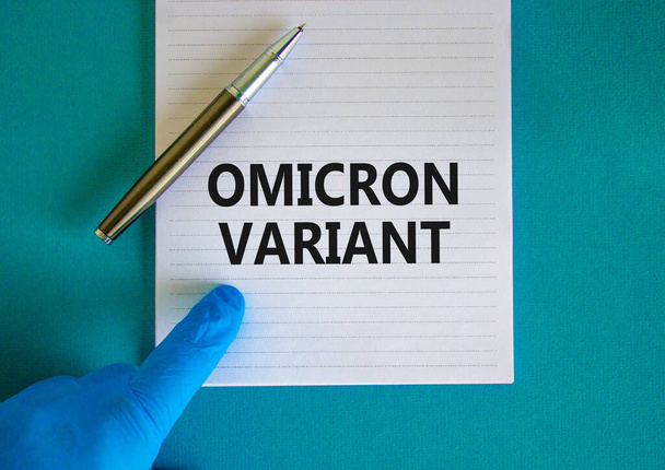 New covid-19 omicron variant strain symbol. Hand in blue glove with white note. Concept words Omicron variant. Metalic pen. Medical and COVID-19 omicron variant strain concept. Copy space. - Foto, Imagem