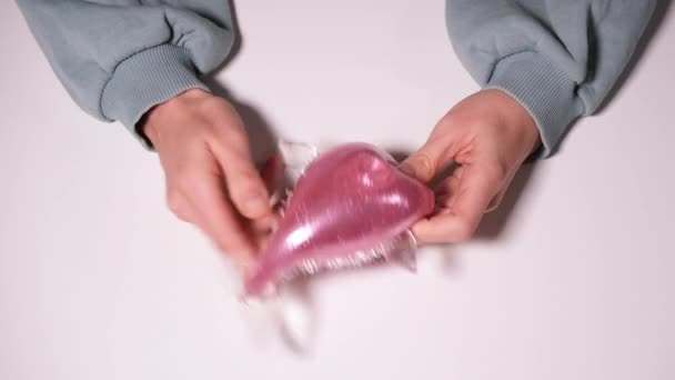 スクイーズピンクの魚と手の遊び手手首運動抗ストレスおもちゃ。ストレス白い背景に隔離された救済のおもちゃ。4k解像度ビデオ - 映像、動画