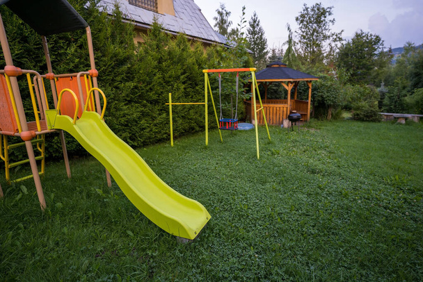 Красочные детские игровые площадки оборудование в парке, такие как слайдер и свингер - Фото, изображение