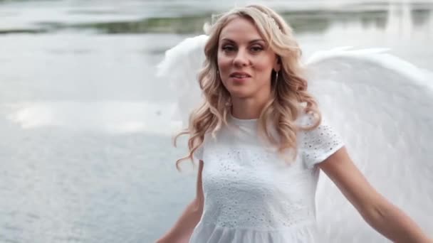 portrait of blonde woman in white dress and white angels wings. good people. heaven, god. paradise angel. slow motion - Footage, Video