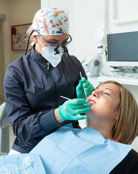 Junge blonde Patientin mit offenem Mund untersucht Zahnuntersuchung in Zahnarztpraxis. - Foto, Bild
