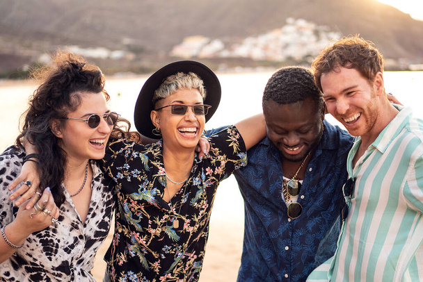 Group of happy multiracial friends having fun together on the beach, dancing and laughing. Mixed race people friendship concept. Multi ethnic students lifestyle. Real people emotions - Valokuva, kuva