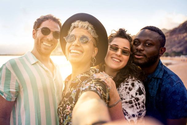 Group of multiracial happy young friends laughing, taking selfie with mobile phone, having fun together on the beach. Multi ethnic friendship concept. Summer time. Traveler. Real people emotions - Fotó, kép