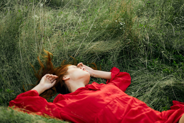 woman in red dress lies on the grass charm freedom - Zdjęcie, obraz