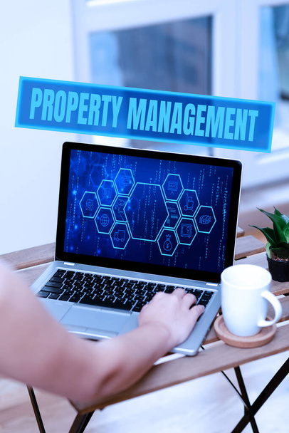 Text sign showing Property Management. Business concept Overseeing of Real Estate Preserved value of Facility Hand Busy Typing On Laptop Beside Coffe Mug And Plant Working From Home. - Photo, Image