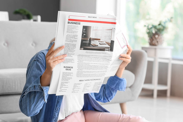 Dojrzałe kobieta czytanie gazety na podłodze w domu - Zdjęcie, obraz