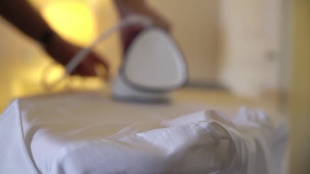 Man ironing a white shirt for a classic suit with an iron on board. - Materiał filmowy, wideo