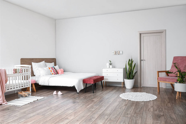 Интерьер стильной светлой спальни с детской кроваткой - Фото, изображение