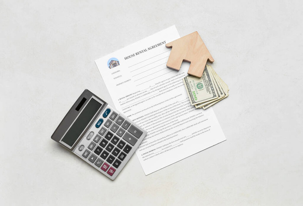 House rental agreement with wooden toy, banknotes and calculator on light background - Photo, Image