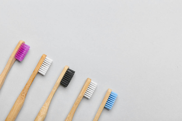 Diferentes escovas de dentes de madeira no fundo cinza, close-up - Foto, Imagem