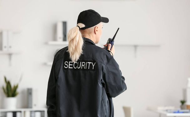 Female security guard with radio transmitter in office - Zdjęcie, obraz
