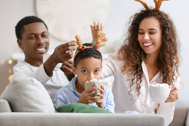 Happy African-American family drinking tasty hot chocolate at home on Christmas eve - Foto, Bild