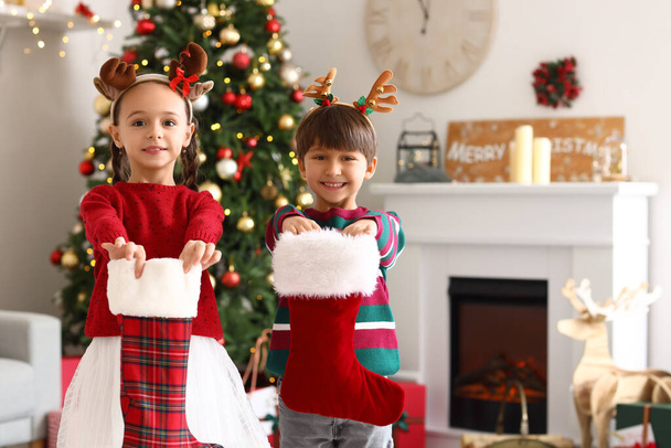 Cute little children with Christmas socks in living room - Photo, Image