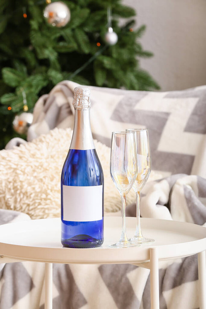 Bottle and glasses of champagne on table in living room - Foto, Bild