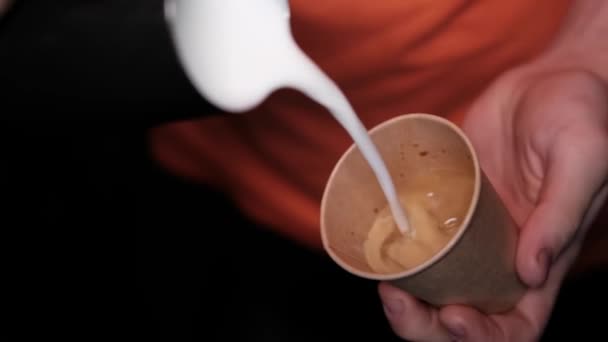 Latte art autorstwa baristy. nalewanie mleka do kawy. ciemna kawiarnia. zwolniony ruch - Materiał filmowy, wideo