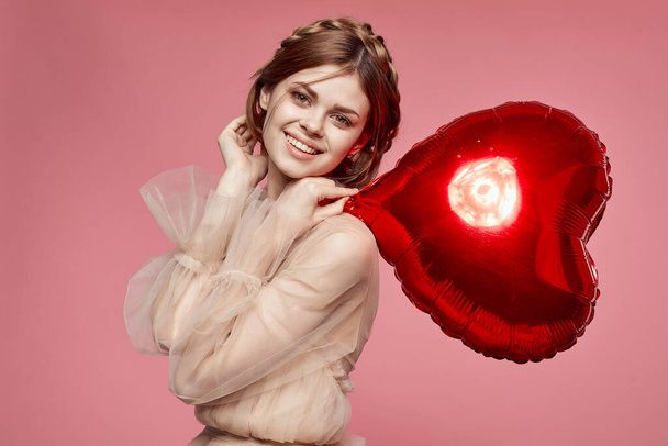 beautiful woman red heart in the hands of the balloon pink background - Photo, Image