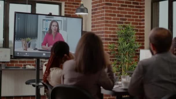 Різноманітна команда колег використовує відеоконференцію, щоб спілкуватися з жінкою
 - Кадри, відео