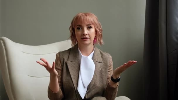 Business woman looks into laptop camera and talks over Internet in office. Boss holds online conference, meeting. - Video, Çekim