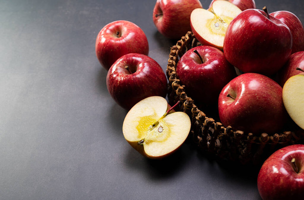 Siyah arka planda tahtadan bir sepet içinde bir sürü elma..  - Fotoğraf, Görsel