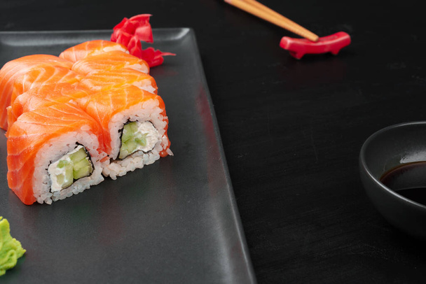Fresh philadelphia sushi roll served on black plate - Foto, Imagem