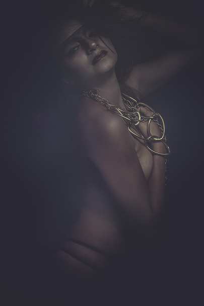 Naked woman with bronze chain - Foto, afbeelding
