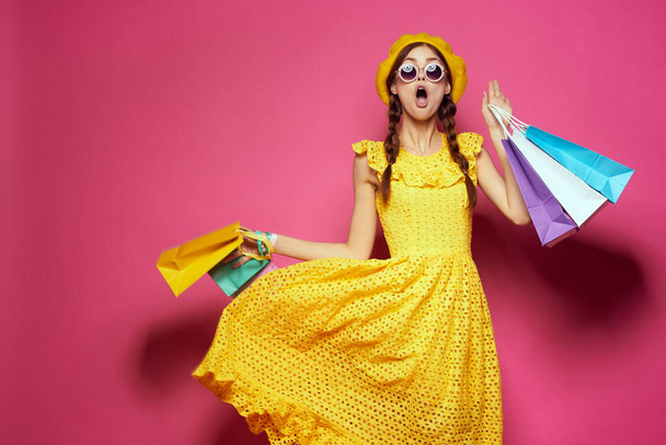 cheerful woman in a yellow hat Shopaholic fashion style pink background - Foto, imagen