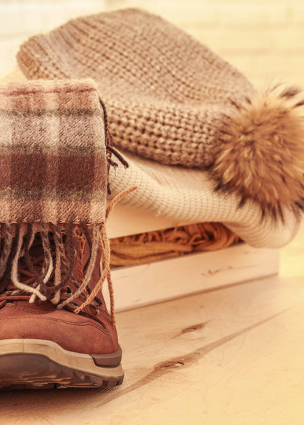 Comfort warm outfit for cold weather. Comfortable shoes, scarf, knitted cloths on wooden background. Cozy winter, autumn  clothes, natural colors - Foto, Bild