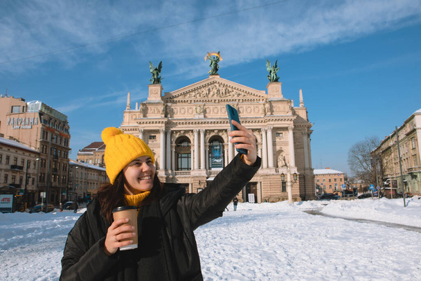 nő utazó iszik kávét menni selfie előtt opera épület Iviv város ukrajnai - Fotó, kép