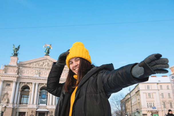 щаслива жінка мандрівник перед оперним театром у Львові міський зимовий сезон засніжене місто
 - Фото, зображення