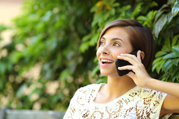 Casual happy woman on the phone in a park - Foto, Imagen