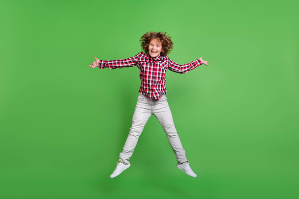 Full length body size view of attractive cheerful guy jumping rest good mood isolated over bright green color background - Фото, зображення