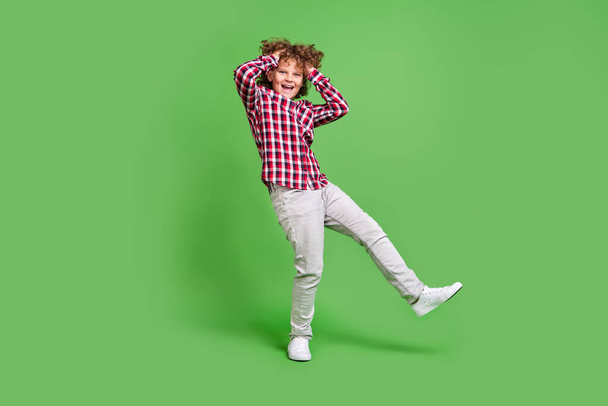 Full length body size view of attractive cheerful funky guy fooling having fun isolated over bright green color background - Фото, зображення