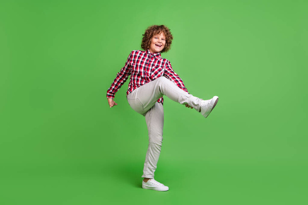 Повнометражний вигляд на тіло привабливого веселого божевільного хлопця, який танцює, що весело ізольований на яскраво-зеленому кольоровому фоні
 - Фото, зображення