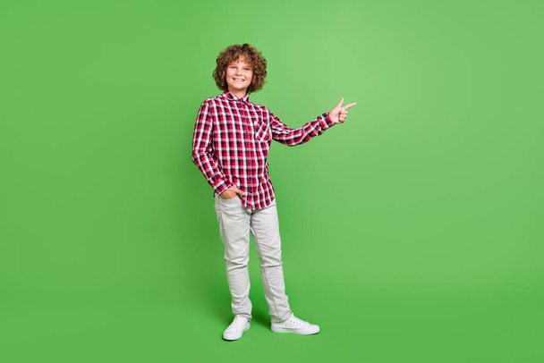 Full length body size view of attractive cheerful guy demonstrating copy space isolated over bright green color background - Φωτογραφία, εικόνα